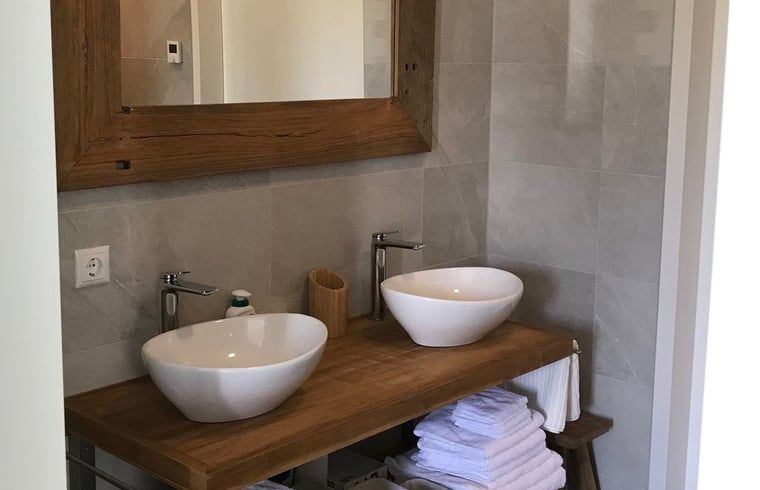 Modernes Badezimmer mit Doppelwaschbecken in einem Ferienhaus in Zeewolde.