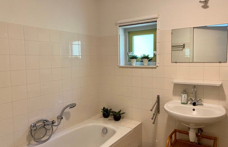 Badkamer met ligbad in Huisje in Oudemirdum, vakantiehuis in Friese bossen, Friesland.