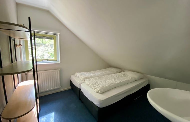 Lichte slaapkamer in Huisje in Oudemirdum, vakantiehuis in Friese bossen, Friesland met uitzicht op groen.