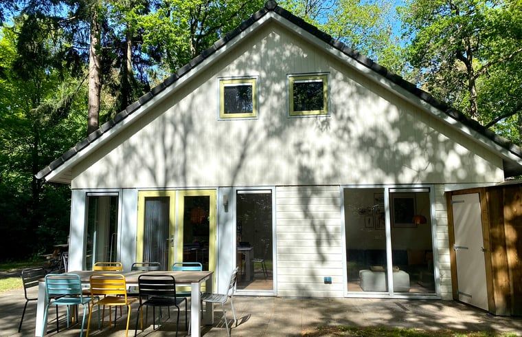 Vooraanzicht van Huisje in Oudemirdum, vakantiehuis in Friese bossen, Friesland met kleurrijk terras.