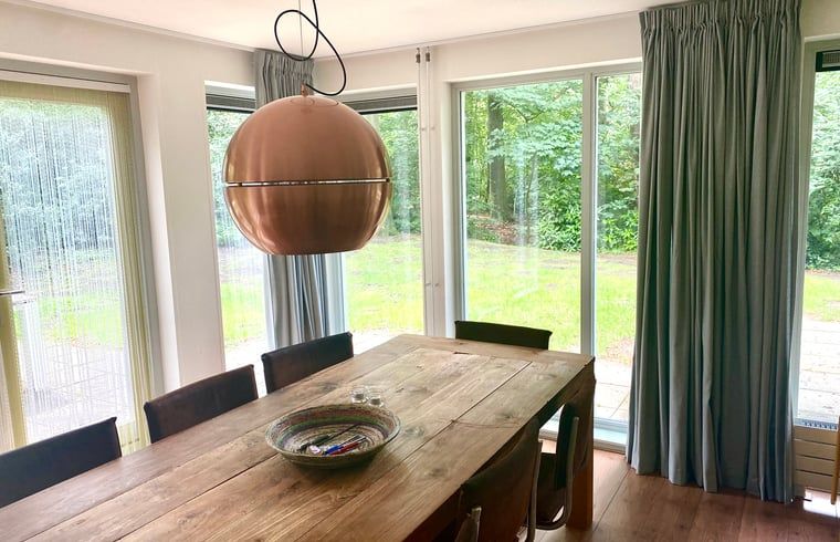 Gezellige eetruimte in Huisje in Oudemirdum, vakantiehuis in Friese bossen, Friesland met uitzicht op tuin.