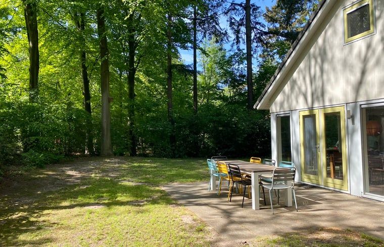Schaduwrijke tuin van Huisje in Oudemirdum, vakantiehuis in Friese bossen, Friesland met eettafel.