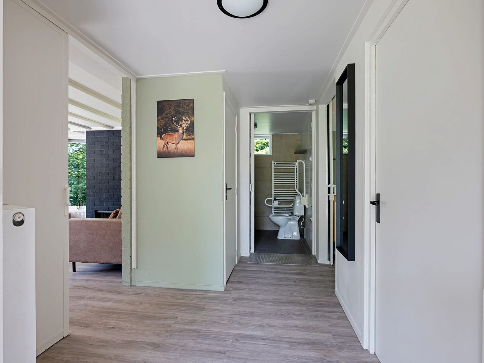 Gang van Aangepaste bungalow de Dobbe in Appelscha, Friese bossen, met toegang tot moderne badkamer en gezellige woonkamer.