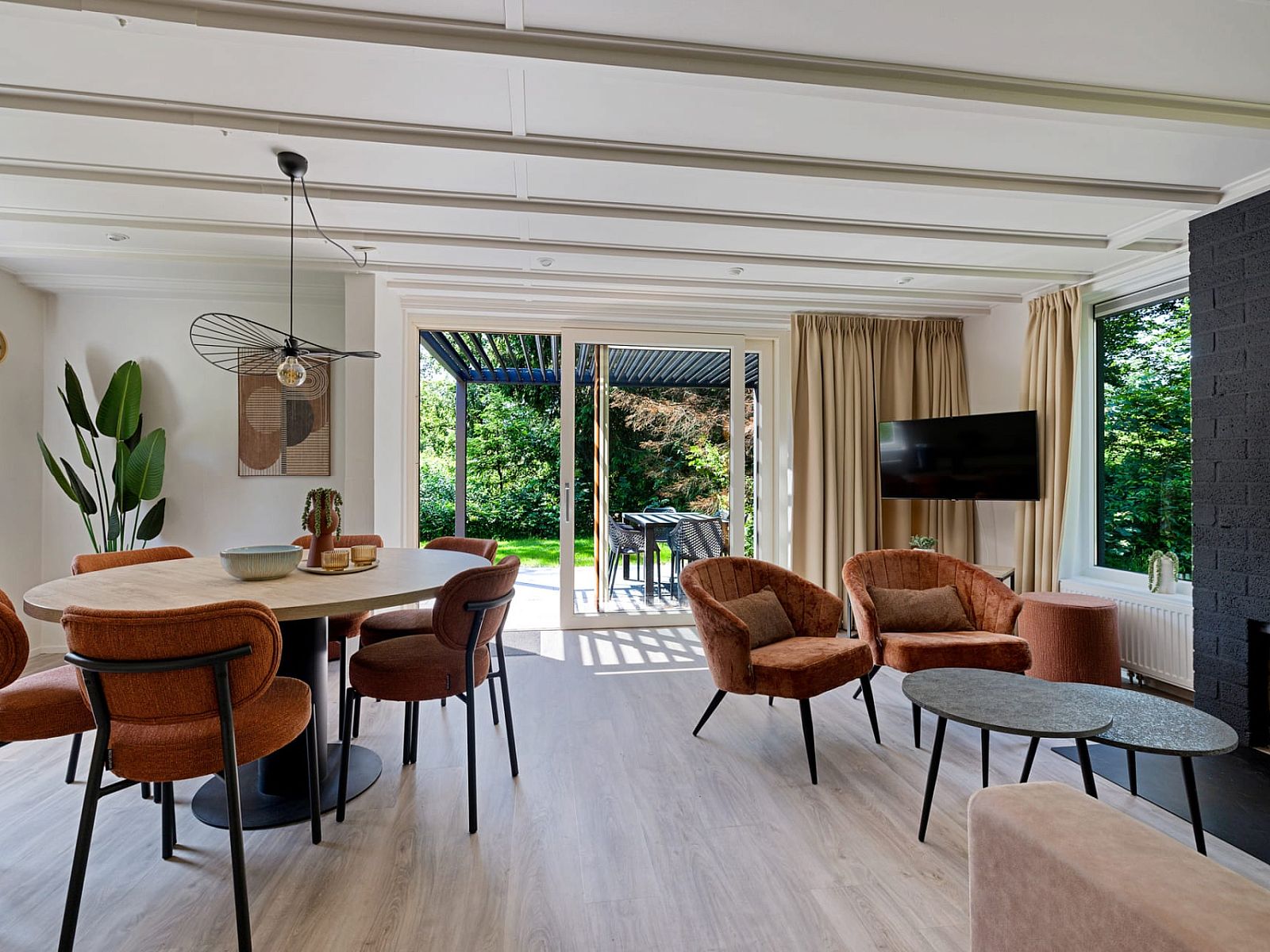 Lichte woonkamer van Aangepaste bungalow de Dobbe in Appelscha, Friesland, met uitzicht op groene tuin vanuit de Friese bossen.