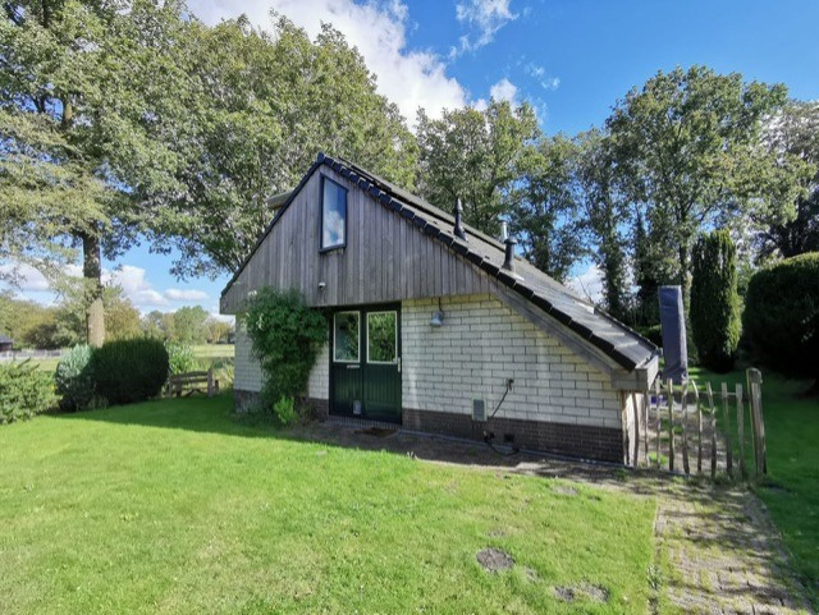 Charmantes Ferienhaus FR433 in Appelscha, Friesland, umgeben von gruenen Waeldern.