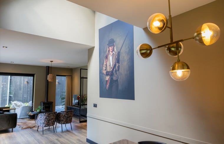 Stylish living room of a cottage in Appelscha, vacation home in the Frisian forests, Friesland, with modern furnishings and art on the walls.