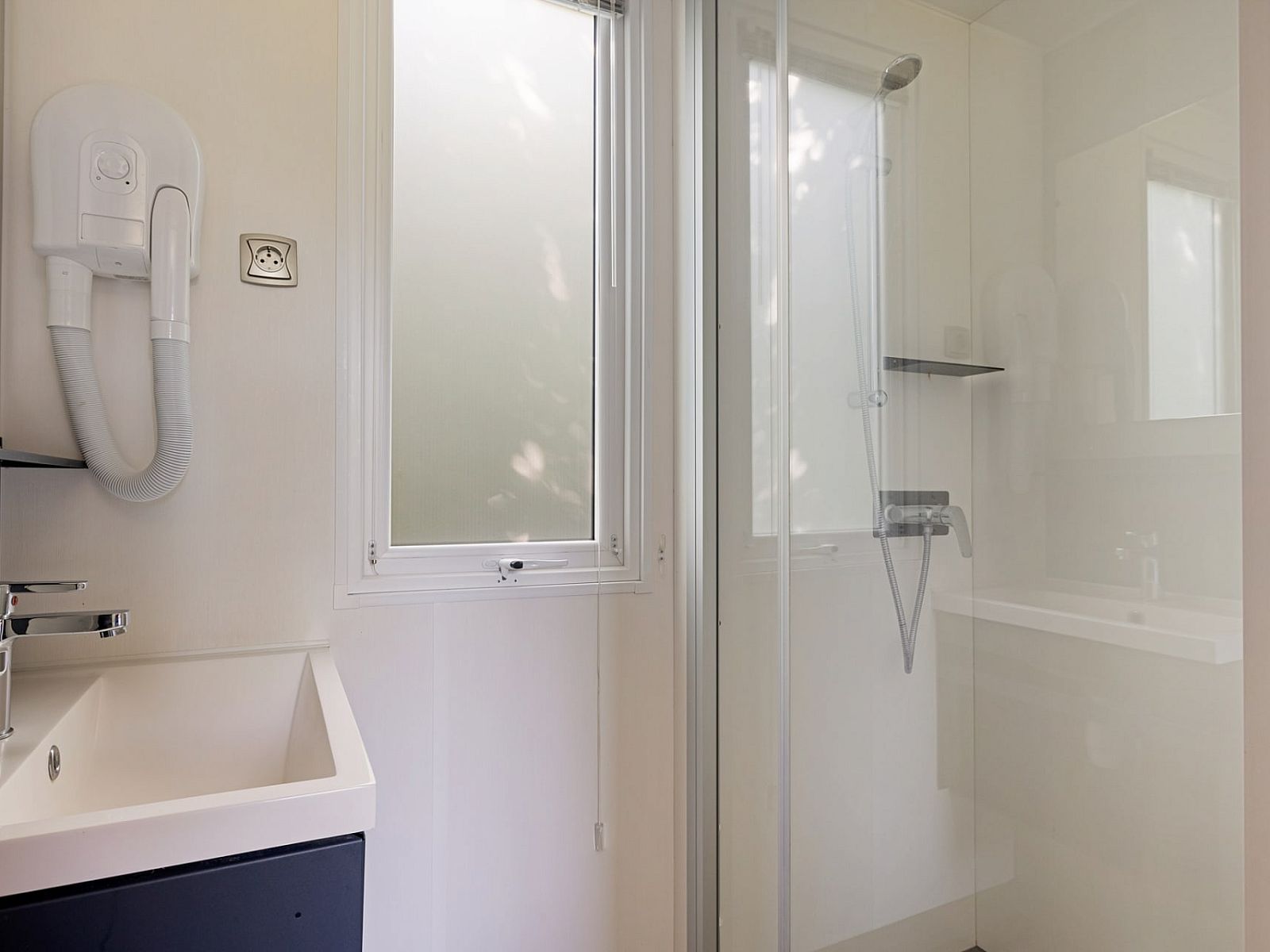 Moderne badkamer in Mobil home de Libelle, Appelscha, met douche en wastafel.