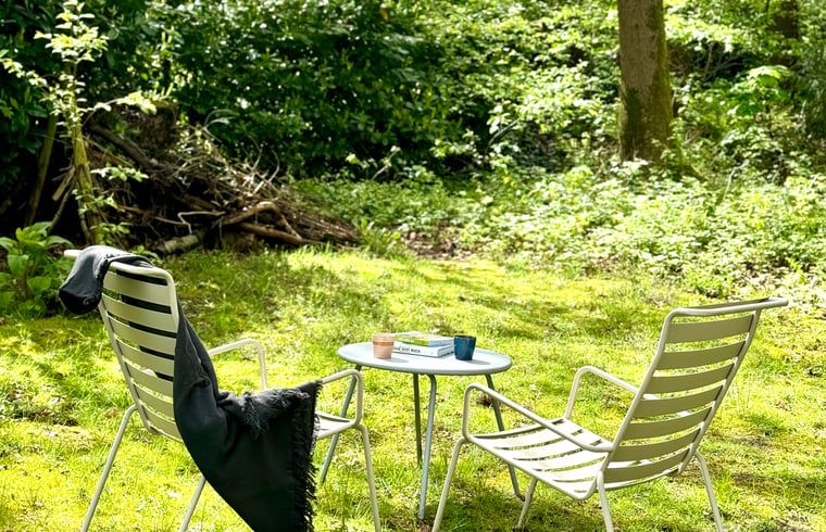 Relaxhoek in de tuin van Huisje in Appelscha, vakantiehuis in Friesland, perfect voor ontspanning.