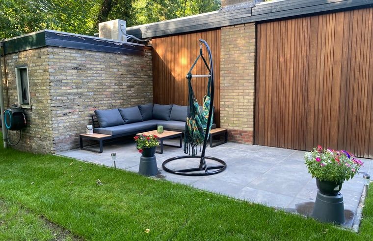 Gemuetliche Sitzecke auf der Terrasse des Ferienhauses in Appelscha, umgeben von der Natur des Friesenwaldes.