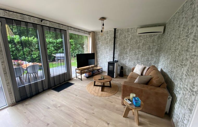 Helles Wohnzimmer des Ferienhauses in Appelscha, mit Blick auf die Terrasse und die friesischen Waelder, Friesland.