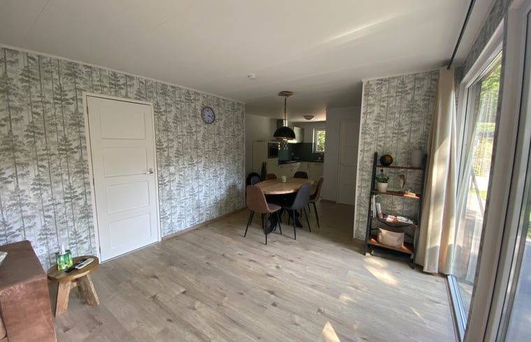 Geraeumiges Esszimmer des Ferienhauses in Appelscha, mit grossen Fenstern und Blick auf die friesischen Waelder, Friesland.