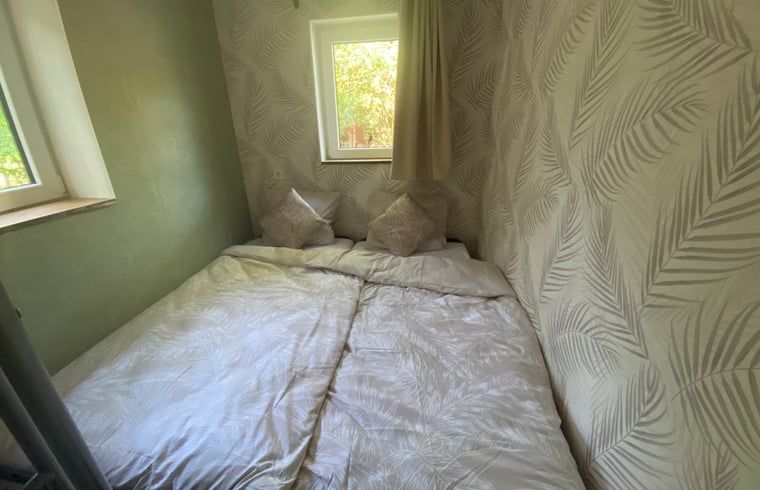 Ferienhaus in Appelscha, gemuetliches Schlafzimmer mit Doppelbett und natuerlichem Licht im friesischen Wald.