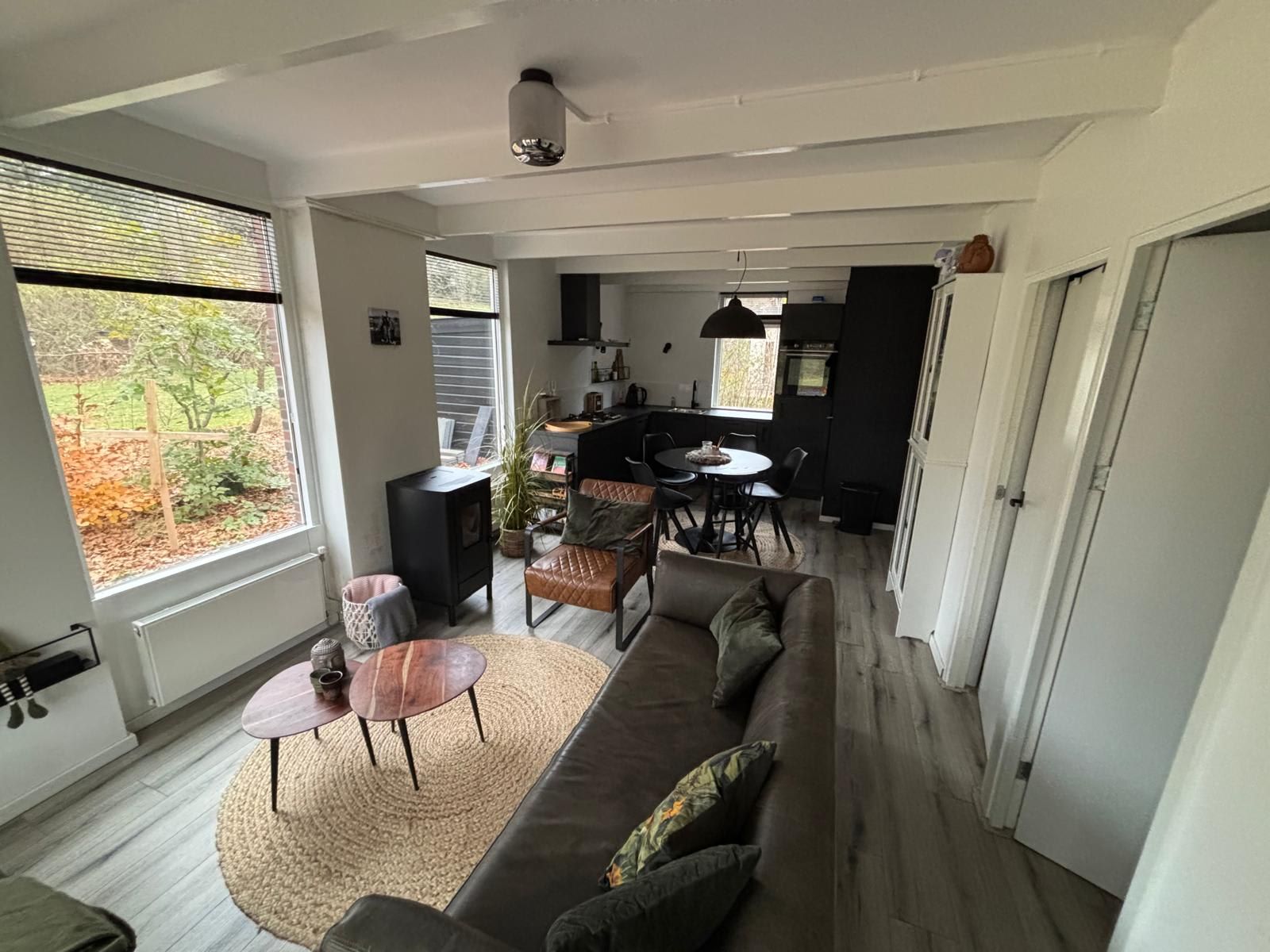 Gemuetliches Wohnzimmer von Bungalow het Goudhaantje in Appelscha, Friesland, mit Blick auf die friesischen Waelder und moderner Einrichtung.