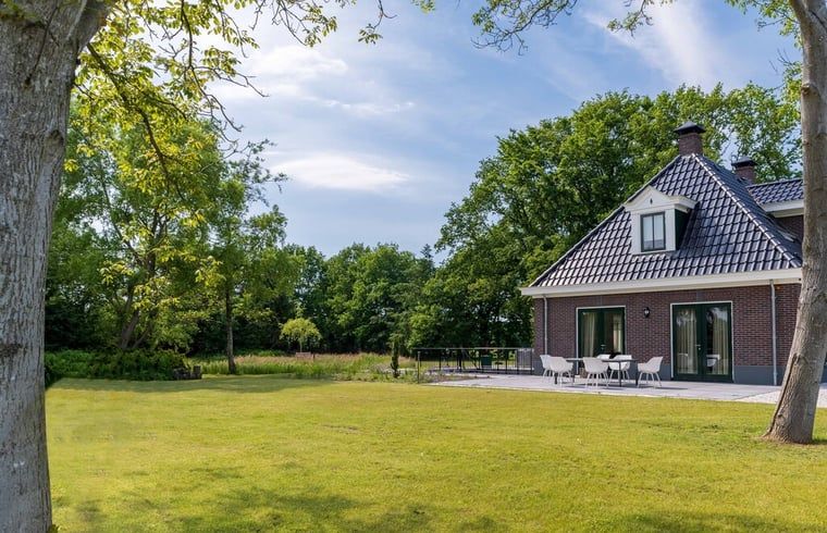 Ruim terras bij vakantiehuisje in Bakkeveen, Friesland, omgeven door natuur.