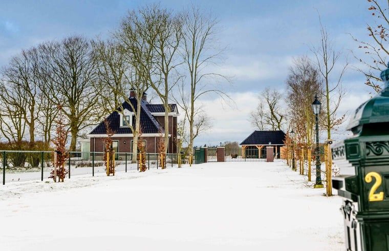 Besneeuwd toegangspad naar vakantiehuisje in Bakkeveen, Friesland.
