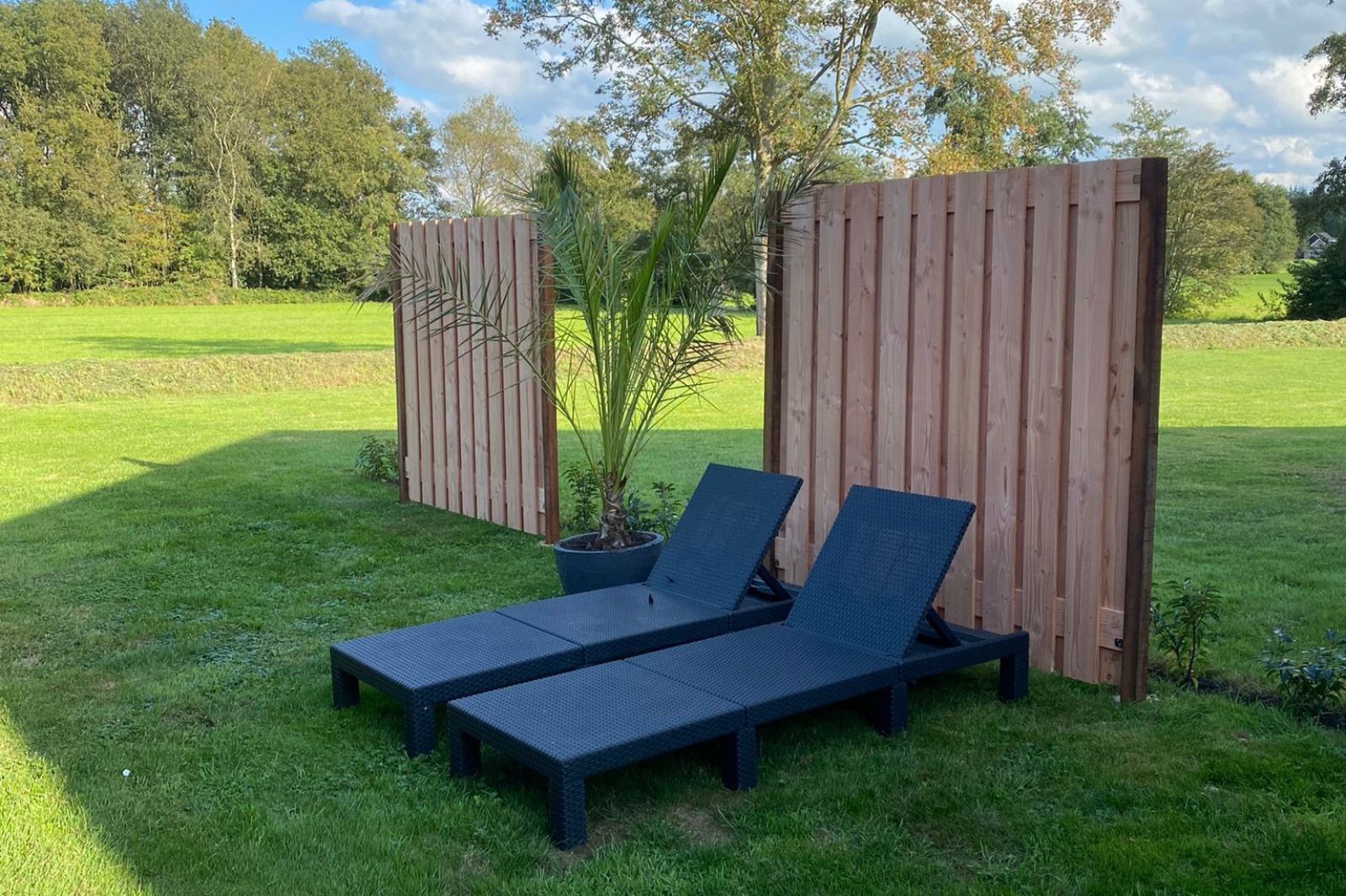 Zonnige tuin met ligstoelen bij vakantiehuis FR439 in Noordwolde, Friesland.