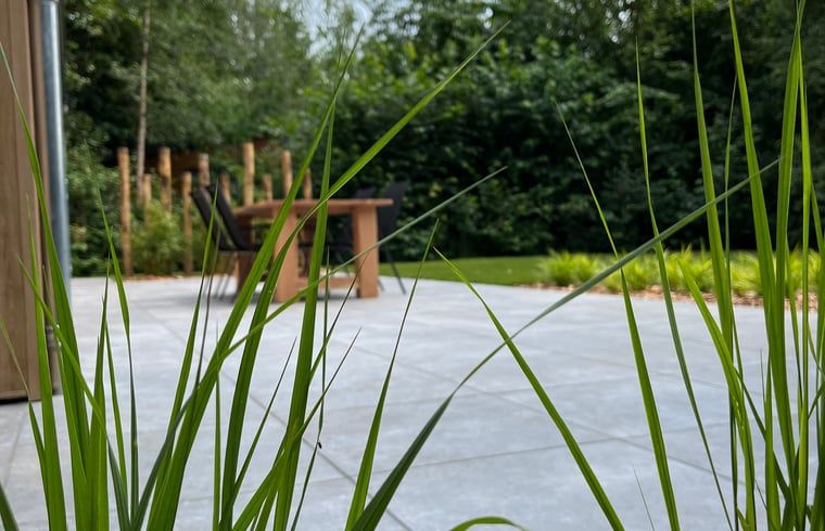 Gruener Garten mit Rasen und Terrasse im Ferienhaus in Oosterwolde, Friesland.
