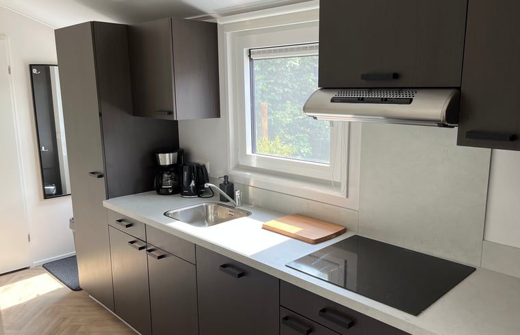 Moderne Kueche im Ferienhaus in Oosterwolde mit viel Licht und friesischem Holz.