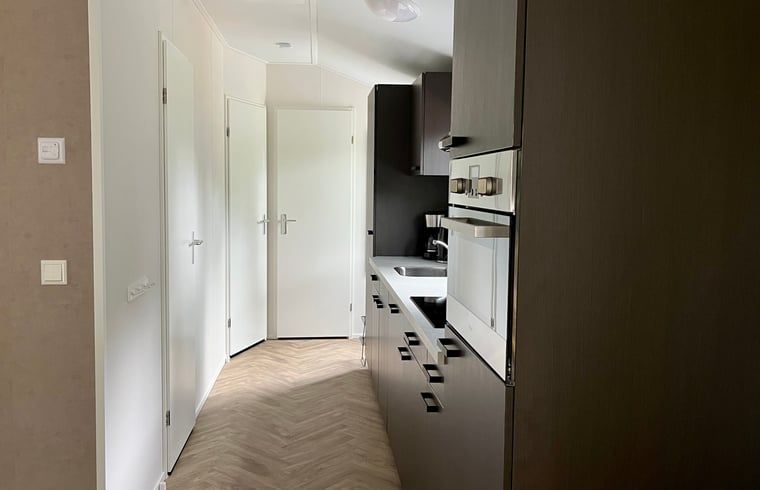 Kueche im Ferienhaus in Oosterwolde mit modernen Geraeten und friesischem Holz.