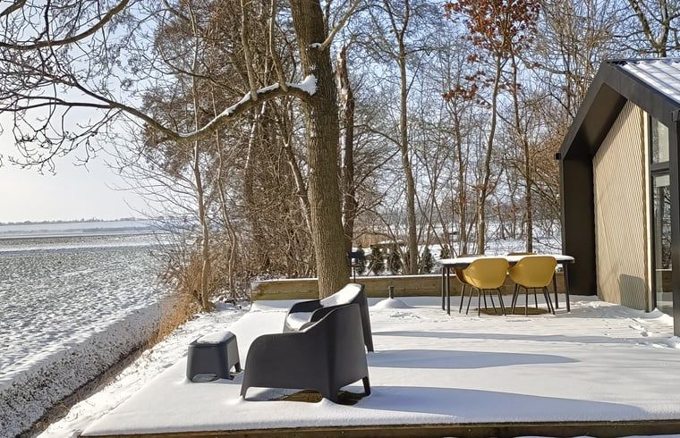 Vacation home in Oosterwolde, located in the Frisian forests of Friesland, with a wooden terrace and surrounded by green nature.