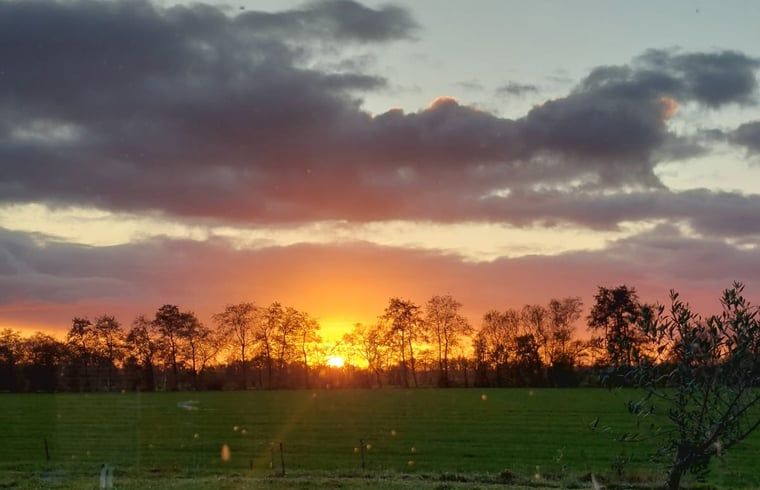 Spectaculaire zonsondergang bij Vakantiehuis in Haulerwijk, omgeven door natuur in Friesland.