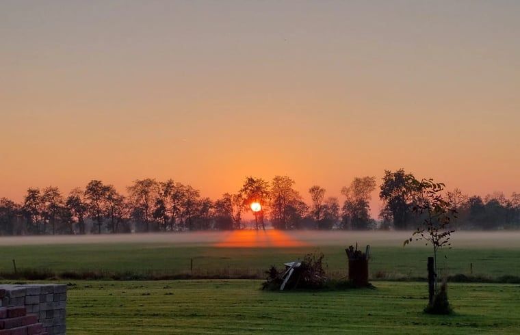 Zonsopgang over de velden bij Vakantiehuis in Haulerwijk, een serene ochtend in Friesland.