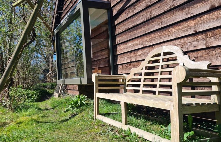 Houten bankje bij Vakantiehuisje in Boijl, perfect voor ontspanning in de Friese bossen.