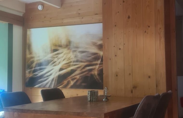 Eetkamer met kunst aan de muur in Vakantiehuisje in Boijl, een sfeervolle plek in Friesland.