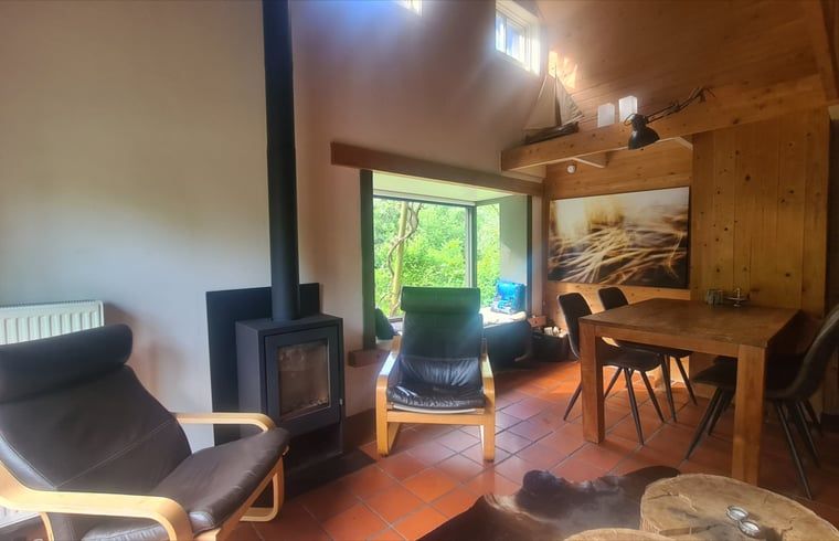 Ruime woonkamer met veel lichtinval in Vakantiehuisje in Boijl, een serene plek in Friesland.