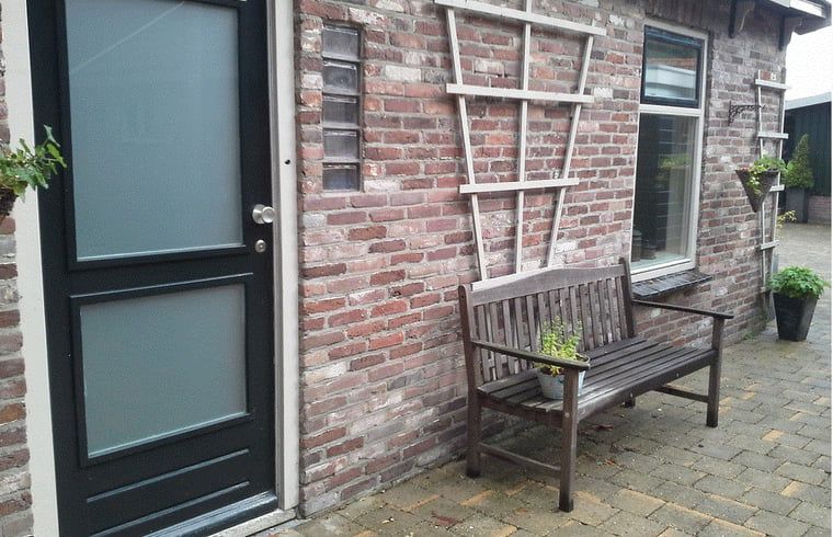 Entrance with wooden bench at Holiday Home in Steggerda, located in Friesland.