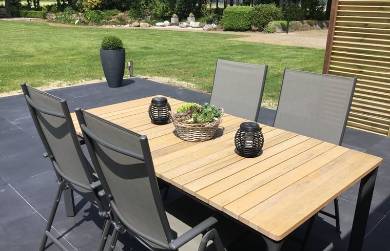 Terrace with dining table in Holiday home in Steggerda, surrounded by Frisian nature.