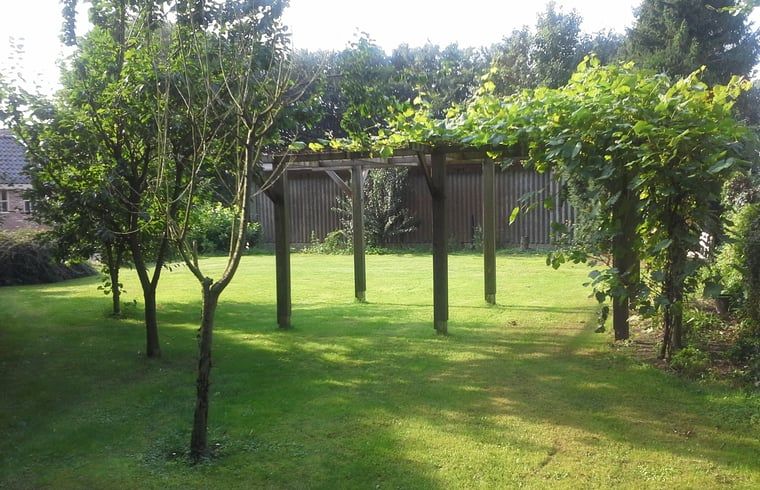 Green garden with pergola at Holiday home in Steggerda, located in Friesland.