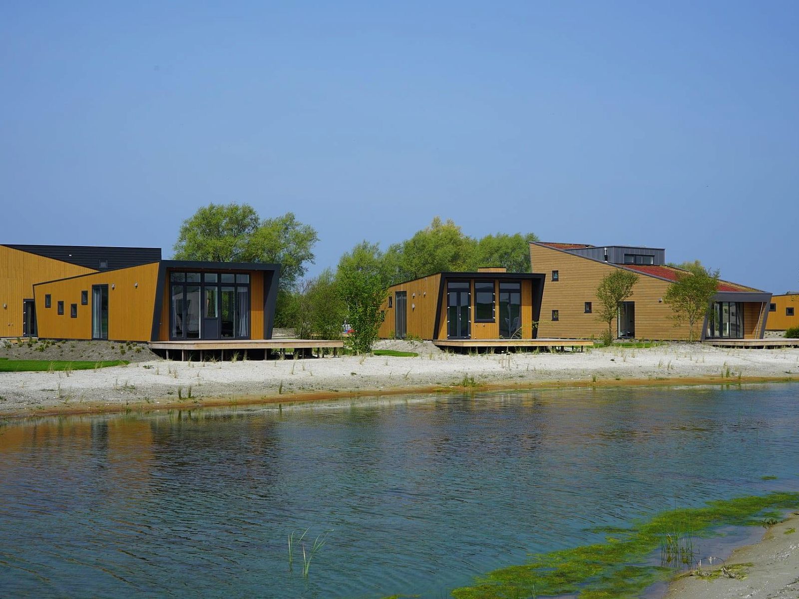 Just Nature MIVA 6 Ferienhaus in Hindeloopen, Friesland, mit moderner Architektur direkt am Wasser und umgeben von ueppiger Natur.