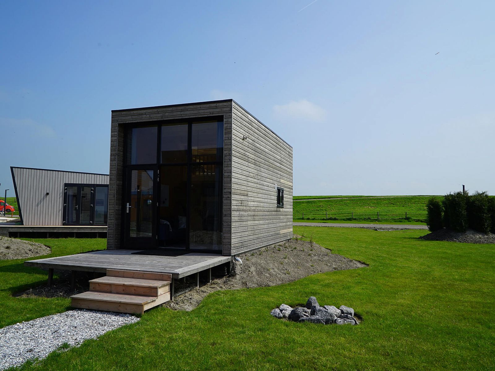 Chalet in Hindeloopen, Friesland, with modern wooden exterior and green surroundings.