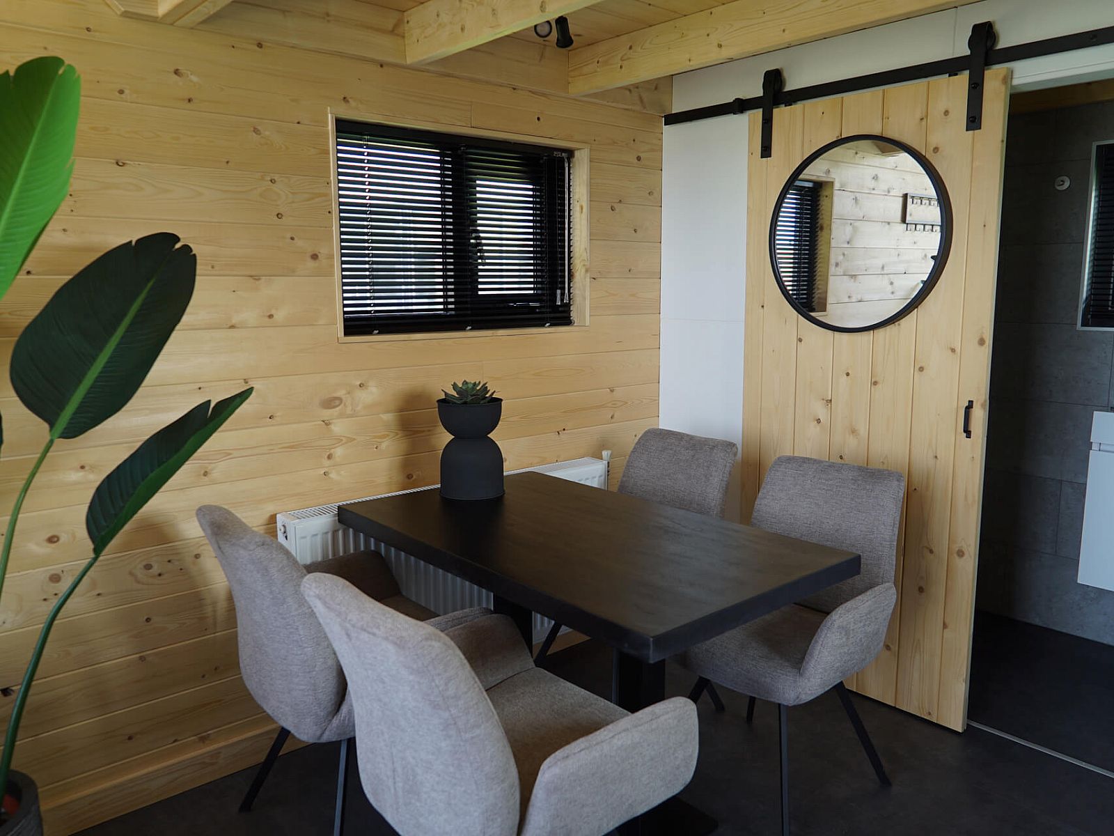 Cozy dining area in Chalet in Hindeloopen, Friesland, with wooden walls and modern furnishings.