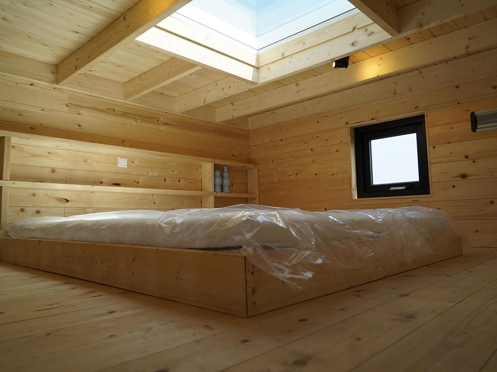 Sleeping loft in Chalet in Hindeloopen, Friesland, with wooden finish and skylight for natural light.