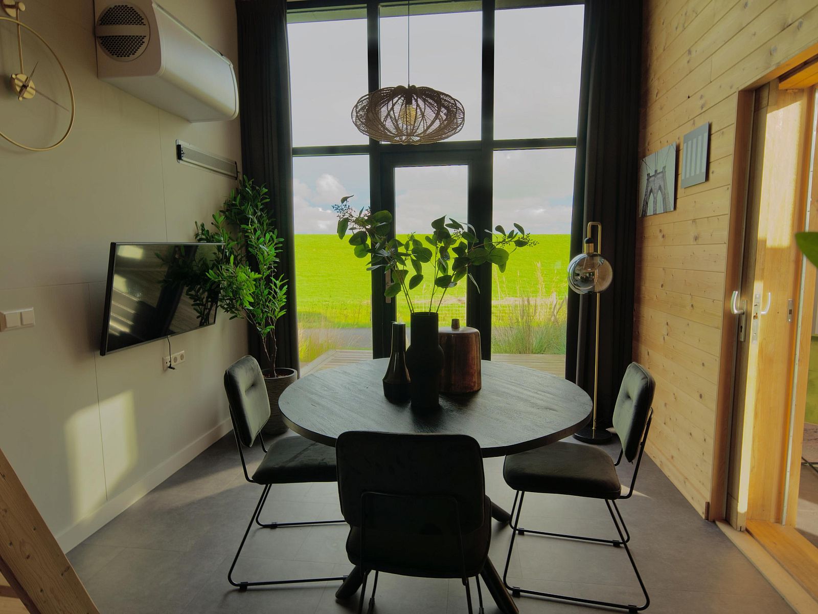 Gemtliches Esszimmer in einem freistehenden Haus in Hindeloopen, Friesland, mit Blick auf grne Felder und moderner Einrichtung.