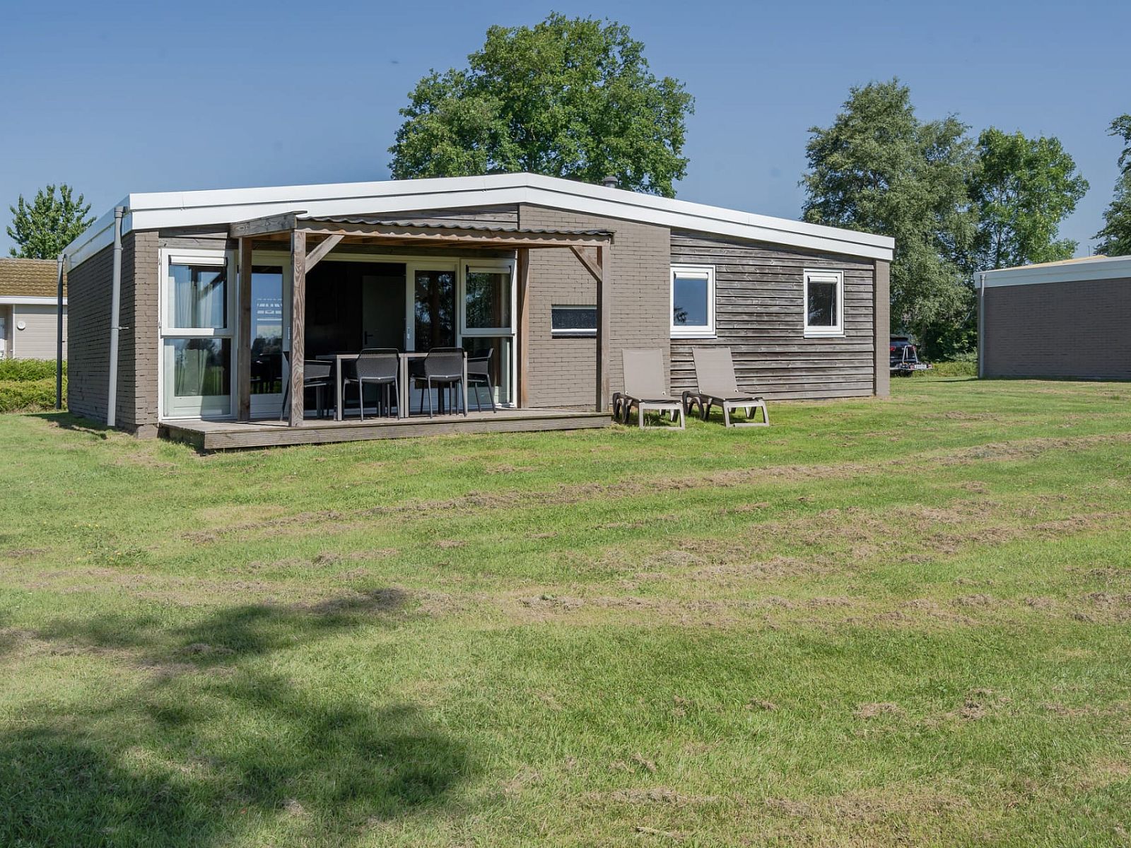 Bungalow de Valk in Offingawier mit grosser Veranda und Liegestuehlen, gelegen am Sneekermeer in den Friesischen Seen.