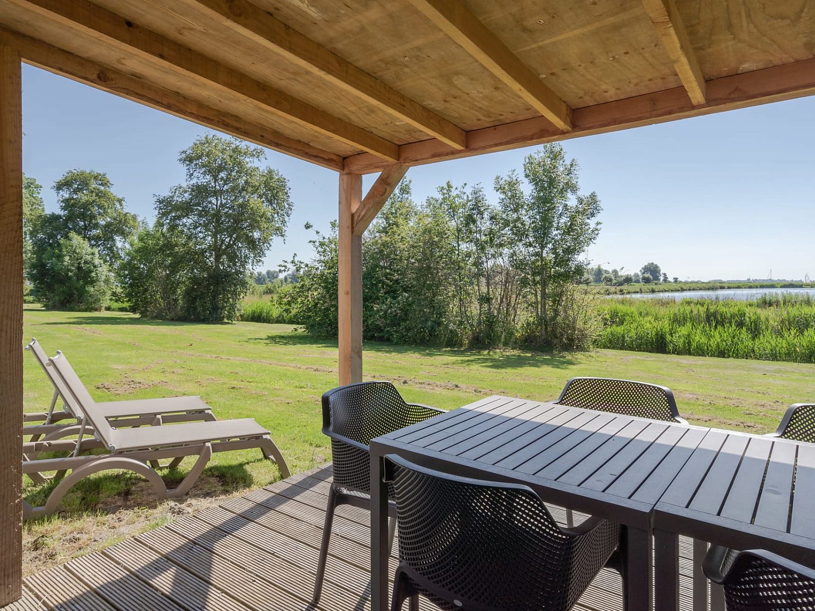 Veranda des Bungalows de Valk in Offingawier mit Blick auf die Natur und das Sneekermeer, ideal zum Entspannen.