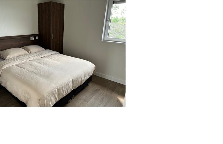 Comfortabele slaapkamer in Vakantiehuis in Blesdijke, Friesland met rustgevend uitzicht.