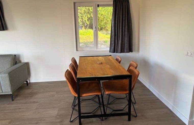 Eetruimte met houten tafel in Vakantiehuis in Blesdijke, ideaal voor gezinsmaaltijden.