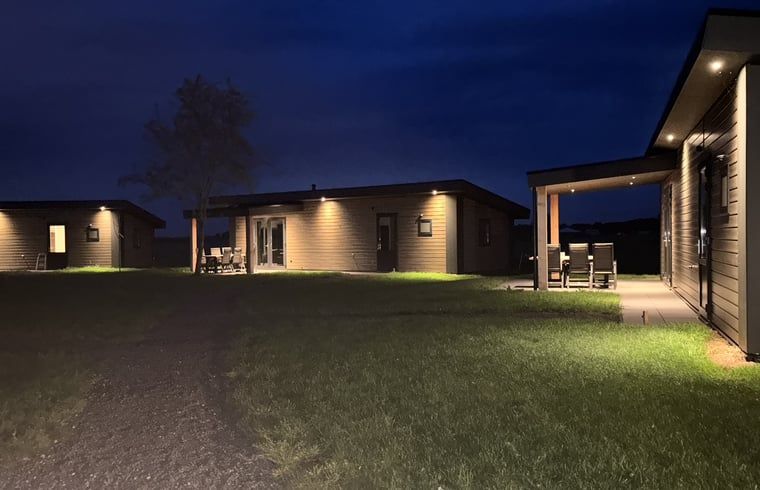 Vakantiehuis in Blesdijke, Friesland verlicht in de avond, serene sfeer.