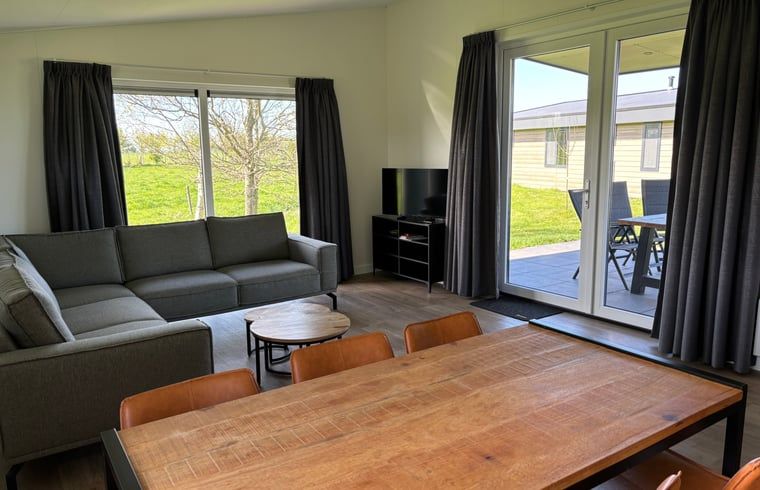 Veranda en woonkamer in Vakantiehuis in Blesdijke met uitzicht op het Friese platteland.