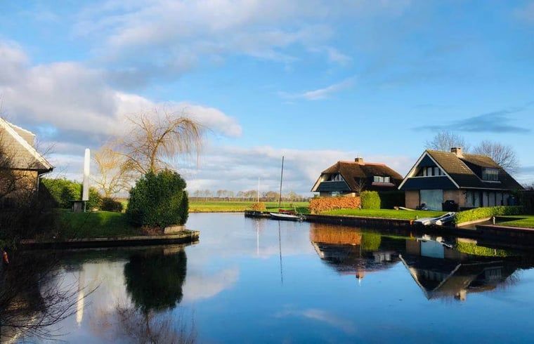 Rustgevend uitzicht vanaf Vakantiehuis in Idskenhuizen op het Friese platteland, met serene waterwegen en landelijke schoonheid.