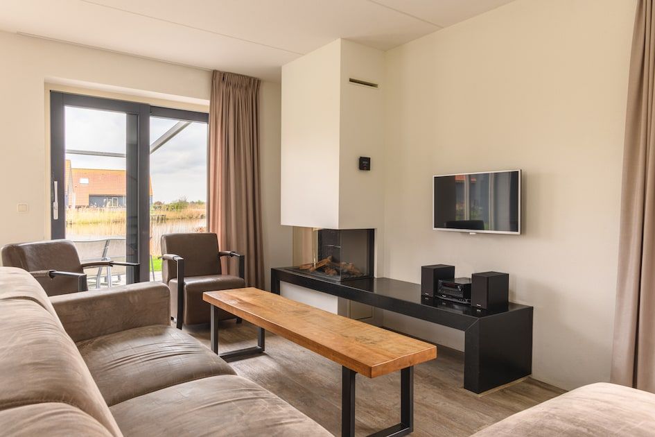 Cozy living room of Watervilla Snoek, a modern bungalow in Langelille, Friesland, overlooking the Frisian countryside.