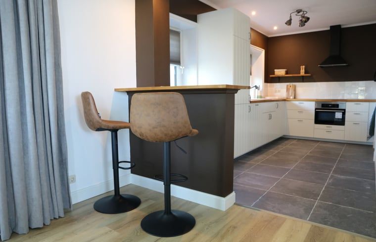 Moderne Kueche mit Bar in Cottage in Wijnaldum, Ferienhaus in der friesischen Landschaft.