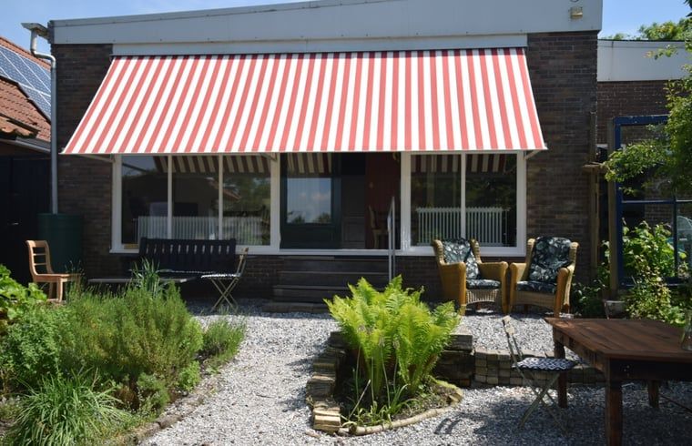 Gezellig terras bij Vakantiehuisje in Munnekeburen, Friesland met comfortabele zitplaatsen en groene omgeving.