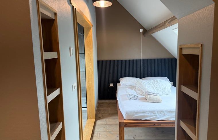 Slaapkamer met houten accenten in Vakantiehuis in Surhuisterveen, rustiek design, Friesland.