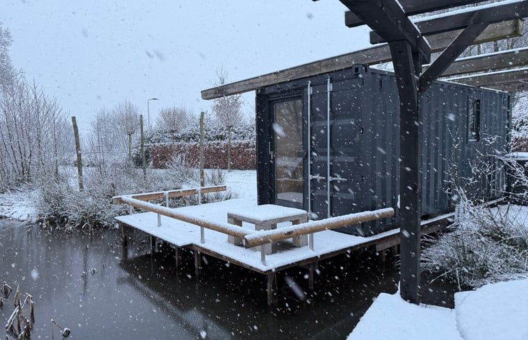 Winterse charme van Huisje in Surhuisterveen met besneeuwd terras in Friesland.