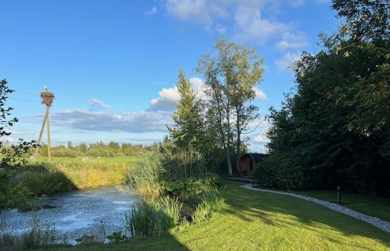 Schoener Garten am Ferienhaus in Spanga mit Teich und gruener Umgebung.